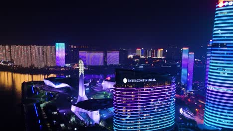 Aerial-zoom-in-on-the-Intercontinental-Hotel-in-Changsha-downtown-at-nighttime,-China