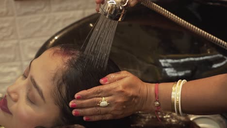 Shot-of-a-young-Asian-woman-getting-her-hair-washed-and-massage-in-a-spa-center,-health-care