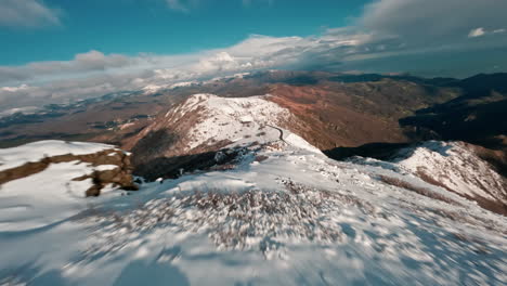 FPV-Drohne-Fliegt-über-Schneebedeckte-Berge-Mit-Atemberaubender-Aussicht-Auf-Die-Landschaft