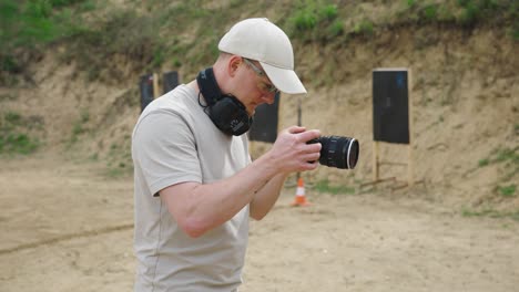 Cameraman-perform-handheld-technique-with-digital-camera,-Olesko-shooting-range