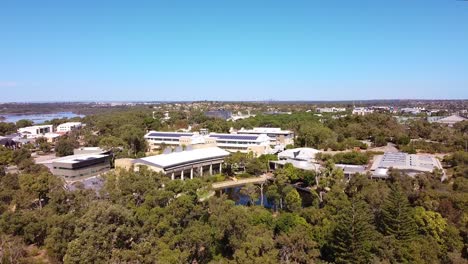 Vista-Aérea-Hacia-Adelante-Hacia-El-Lago-Central-Park-Y-Los-Edificios-North-Metro-Tafe,-Joondalup-Perth