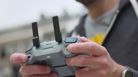 Man-piloting-drone-with-remote-control.-Close-up