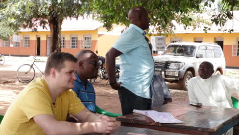 Un-Grupo-De-Hombres-Teniendo-Una-Discusión-En-Una-Mesa-Al-Aire-Libre-En-Kampala,-Uganda