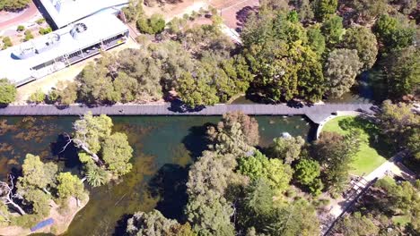 Aerial-dolly-right-view-over-Central-Park-Joondalup-with-lake-and-footbridge,-Perth