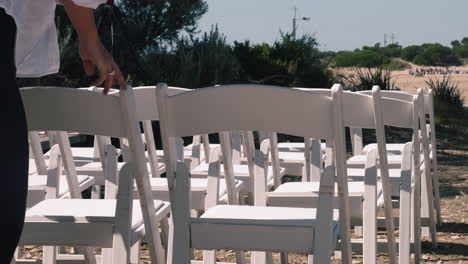 White-Chairs-Being-Adjusted-Before-Wedding-Ceremony