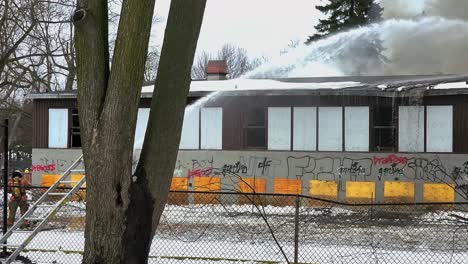 School-on-fire-being-extinguished-by-Canadian-firefighters-with-water-gun