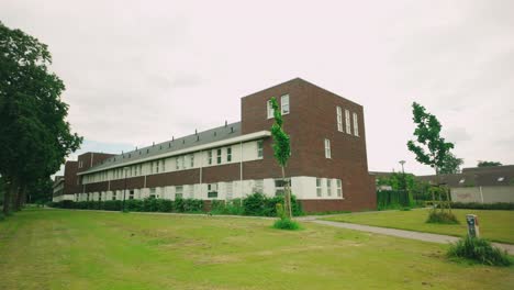 Footage-of-a-modern-square-brick-house-and-apartment-block-in-Lelystad,-surrounded-by-greenery