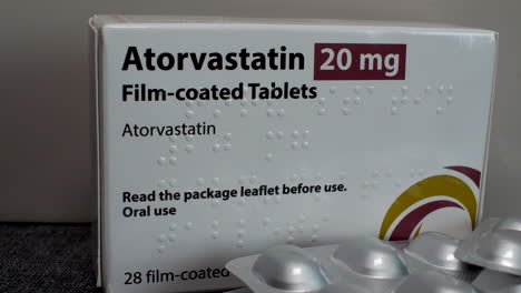 A-close-up-of-a-box-of-Atorvastatin-20-mg-with-an-opened-blister-pack-of-film-coated-tablets-in-the-foreground