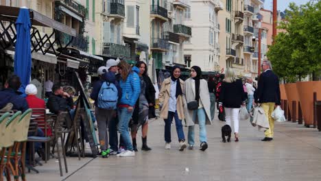 People-strolling-through-lively-street-in-Cannes,-France-on-pleasant-day