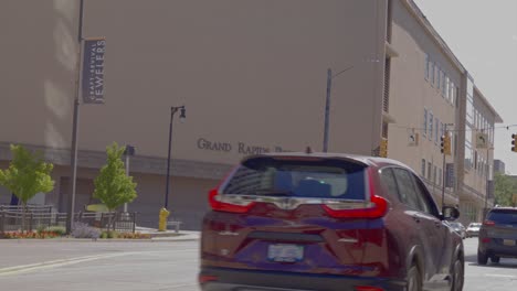 Exterior-sign-of-Grand-Rapids,-Michigan-police-department-with-vehicles-driving-by-and-stable-video-wide-shot