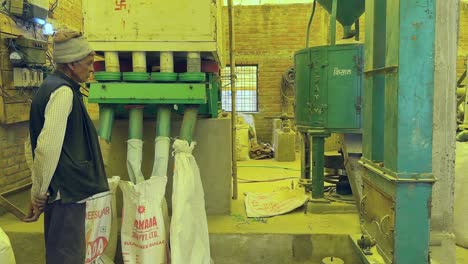 Indian-Farmer-Waiting-for-finished-rice-from-its-raw-rice-during-the-process-of-Rice-Milling