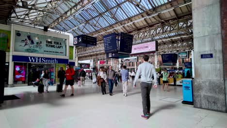 Viajeros-Y-Viajeros-En-Una-Bulliciosa-Estación-De-Tren-Con-Tiendas-Minoristas-Y-Carteles-Que-Capturan-La-Esencia-Del-Tránsito-Diario.