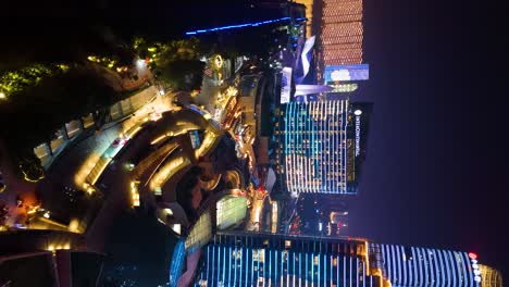 Vertical-aerial-zoom-in-on-the-Intercontinental-Hotel-with-shops-and-restaurants-in-the-surrounding-area-in-Changsha-downtown-at-nighttime,-China