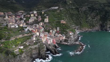Riomaggiore-Cinque-Terre-Italy-aerial-sun-shines-spotlight-on-the-oceanside-village