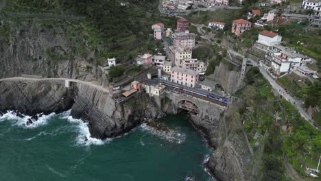 Riomaggiore-Cinque-Terre-Italy-aerial-waves-crash-below-bridge