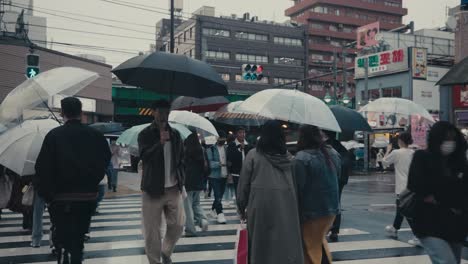 Peatones-Cruzando-La-Calle-En-La-Húmeda-Ciudad-De-Tokio,-Japón