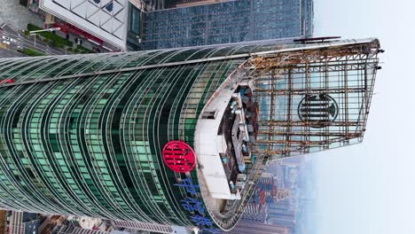 Vertical-aerial-orbiting-shot-around-a-skyscraper-of-Citic-Bank-in-Changsha-revealing-cityscape-in-heavy-air-pollution-with-the-Xiang-River-in-the-background