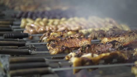 Close-up-of-chicken-skewers-on-grill-over-open-fire