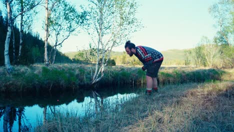 A-Man-Watches-the-Marker-on-the-Creek-and-Checks-the-Water-Conditions-for-Fishing---Static-Shot