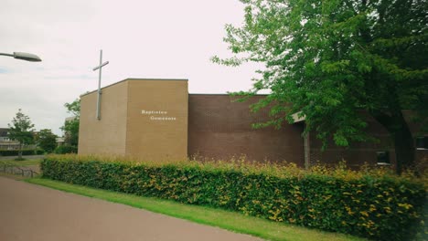 Footage-of-the-brickstone-square-Baptisten-Gemeente-Protestant-church-in-Lelystad,-showcasing-its-unique-architecture-and-surrounding-area