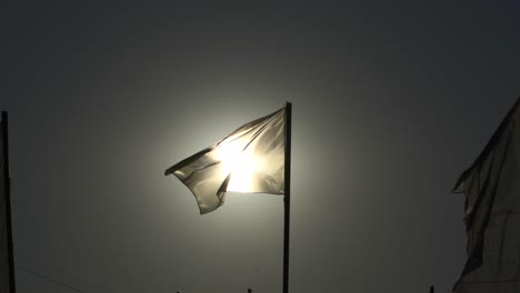 El-Sol-Brilla-Detrás-De-La-Bandera-Blanca-En-Un-Día-Soleado.