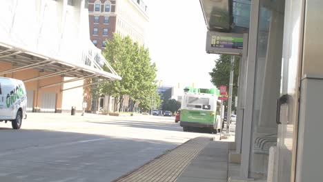 Bus-station-in-Grand-Rapids,-Michigan-with-bus-pulling-away-with-stable-wide-shot