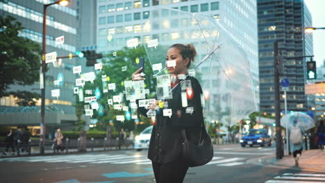 Elegant-young-woman-stands-in-rain-of-big-city-with-a-transparent-umbrella-and-checks-her-social-media-accounts,-digitally-animated-emoticons,-wide-shot