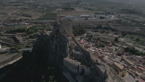 Historic-castle-on-a-hill-overlooking-the-town-of-Biar-in-Alicante,-Spain,-aerial-view