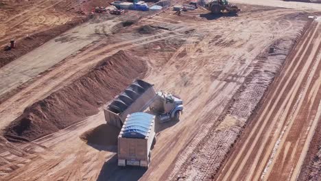 Truck-and-trailer-tipping-dirt-from-the-front-bin-near-the-rear-bin-pile-at-a-construction-site-in-Yarrawonga