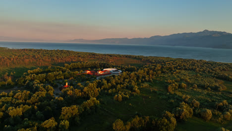 Establishing-drone-shot-of-the-Plavnica-Eco-Resort,-sunset-at-Skadar-lake,-Montenegro