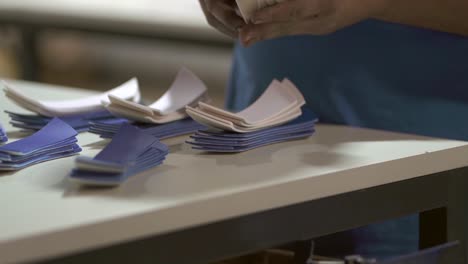 Factory-worker-sorts-out-all-cutted-volleybal-fabric-material-shapes-on-her-worktable