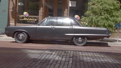 Antique-car-in-front-of-Daises-Place-in-downtown-Grand-Rapids,-Michigan-with-stable-video-shot