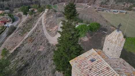 Oristas,-an-old-town-in-barcelona,-spain,-surrounded-by-rolling-hills-and-greenery,-aerial-view