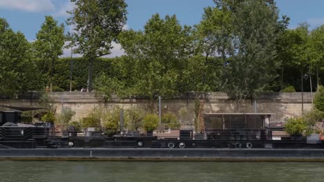 View-from-a-boat-on-the-river-Seine-following-the-quayside-on-a-sunny-day