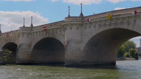 Vista-Desde-Un-Barco-Fluvial-Que-Pasa-Bajo-El-Famoso-Pont-Neuf-En-París