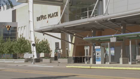 Exterior-of-DeVos-Place-in-downtown-Grand-Rapids,-Michigan-and-person-walking-in-front-with-stable-wide-shot