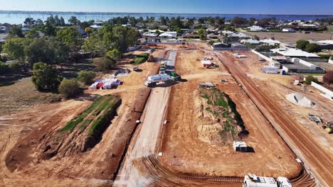 Estabilizador-De-Suelo-Y-Un-Camión-Cisterna-Moviéndose-Alrededor-De-La-Nueva-Etapa-De-Un-Sitio-De-Construcción