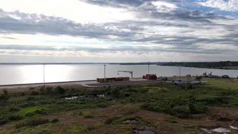 Vuelo-Aéreo-Sobre-El-Puerto-De-Posadas,-Presentando-Una-Perspectiva-única-Del-Patio-De-Contenedores-Y-La-Infraestructura-Marítima.