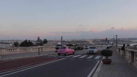 Street-traffic-and-pedestrians-navigate-an-area-in-Valletta,-Malta