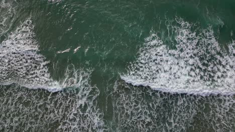 Waves-crashing-on-the-shores-of-port-ginesta,-barcelona,-aerial-view