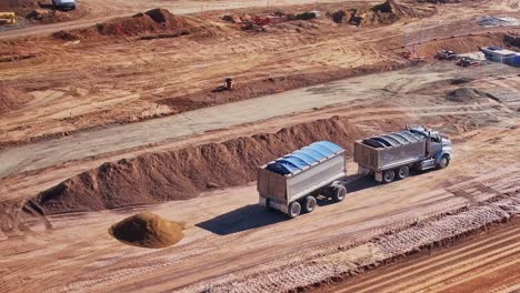 Truck-and-trailer-backing-up-to-unload-dirt-from-front-bin-at-a-construction-site-in-Yarrawonga