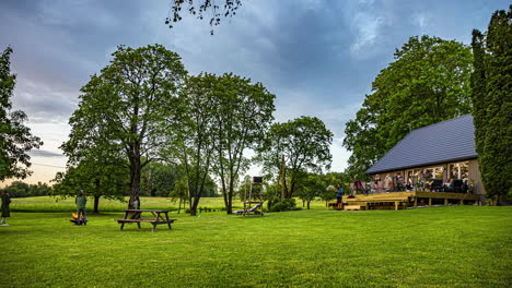 Large-group-of-people-gather-for-a-celebration-at-a-countryside-cottage---time-lapse