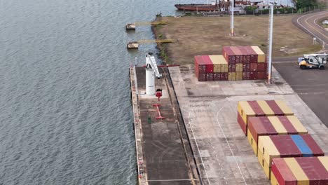 An-orbiting-drone-shot-above-the-containers-at-Posadas-Port,-showcasing-the-intricate-layout-and-vibrant-colors-of-the-shipping-containers