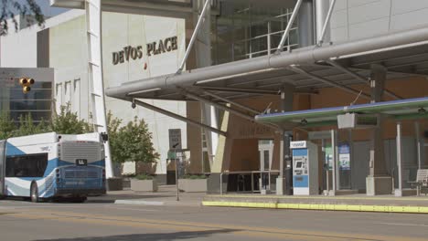 Bus-pulling-away-in-front-of-DeVos-Place-in-downtown-Grand-Rapids,-Michigan-with-stable-video-shot