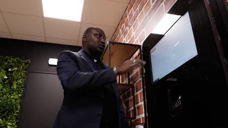 Low-angle-shot-of-a-man-explaining-how-to-order-food-and-drinks-from-a-tablet