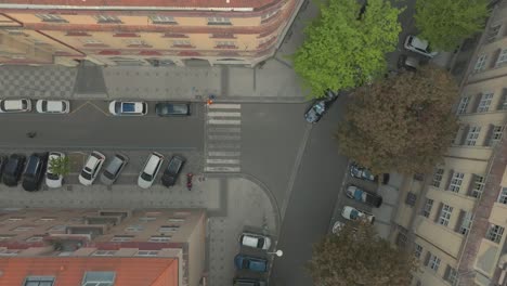 Aerial-drone-reveals-streets-of-Prague-city-during-daylight,-zooming-into-sidewalk