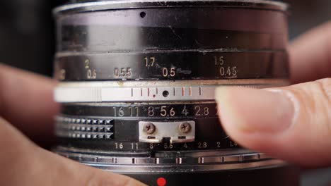 Hands-adjusting-the-lens-aperture-of-a-vintage-camera