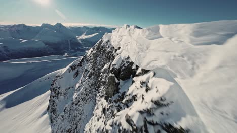 Sonniger-Tag-über-Schneebedeckten-Alpenbergen-In-Norwegen,-FPV-Luftaufnahme