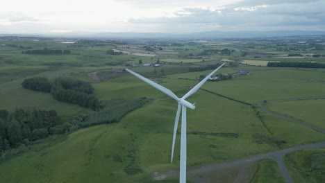 Aerial-orbits-spinning-wind-turbine-on-hazy-day-at-Whitelee-Windfarm