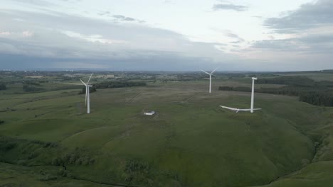 Aerial-tilts-to-wind-turbines-spinning-on-rolling-grey-Scottish-moor